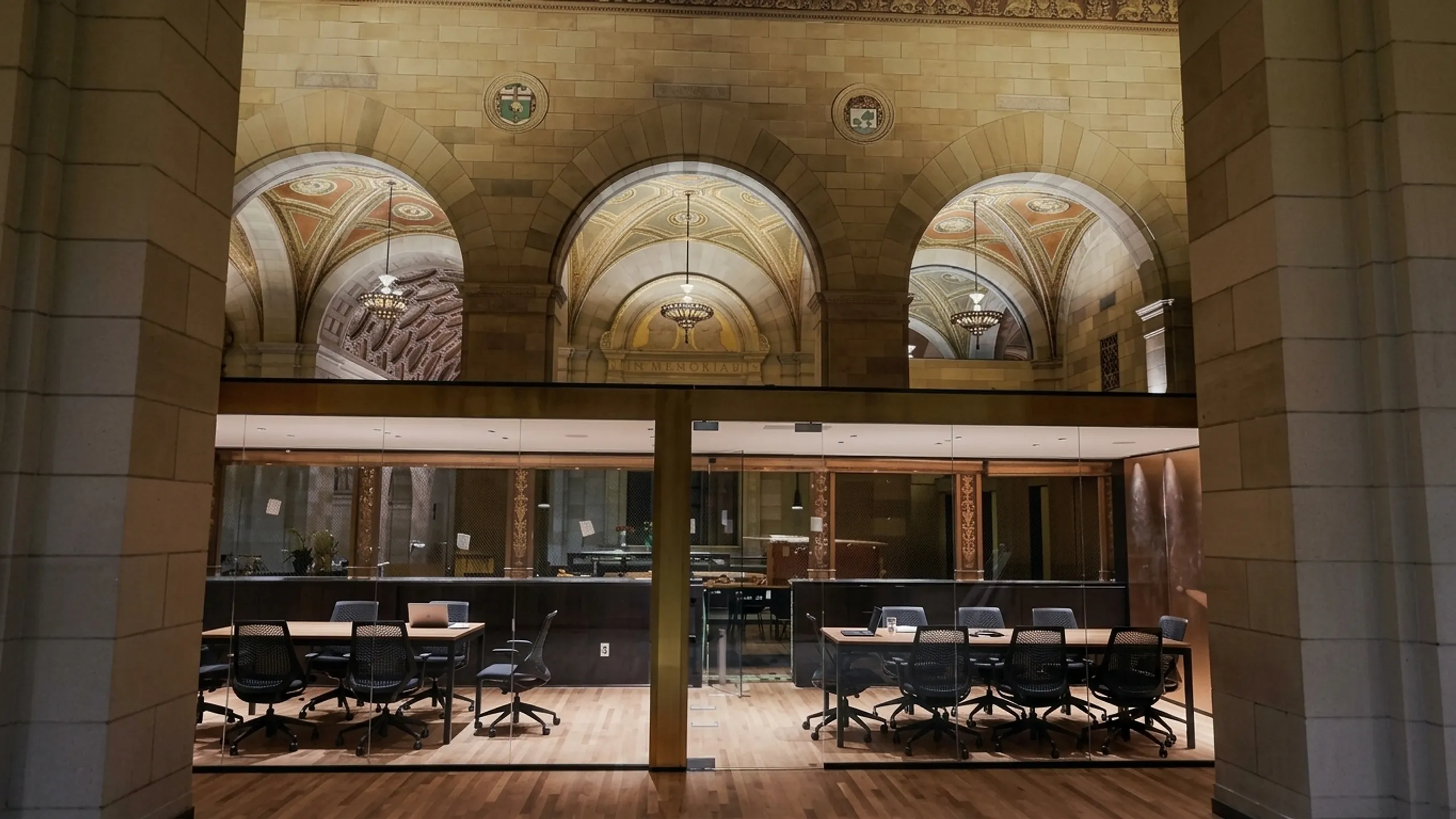 Salle de conférence contemporaine vitrée insérée dans un grand hall architectural patrimonial, cloison de verre toute hauteur